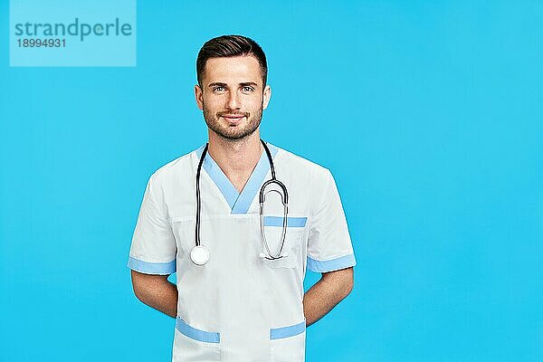 Porträt eines zuversichtlich lächelnden männlichen Arztes mit Stethoskop in medizinischer Uniform mit Kopierraum auf blauem Hintergrund