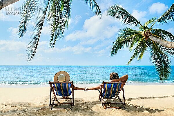Paar am Strand entspannen und genießen Sie das schöne Meer auf der tropischen Insel. Sommer Strandurlaub Konzept