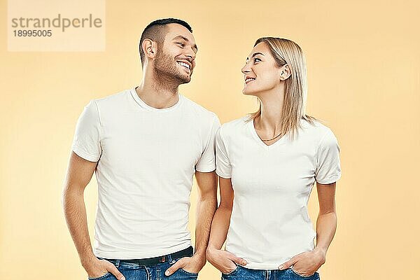 Junges glückliches Paar in der Liebe Blick zueinander über beige Hintergrund. Beziehung  Flirten Konzept