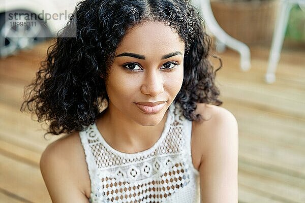 Porträt der jungen schönen afrikanischen amerikanischen weiblichen Modell lächelnd im Freien. Frau Schönheit Konzept