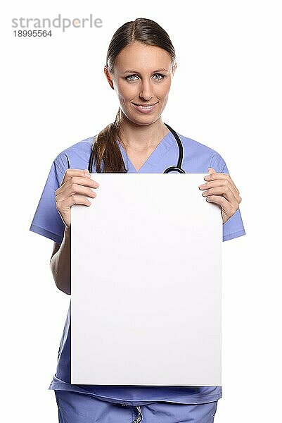 Attraktive junge Ärztin  Tierärztin oder Krankenschwester  die ein leeres weißes Plakat in den Händen hält  mit Platz für Ihren Text oder Ihre Werbung  vor weißem Hintergrund