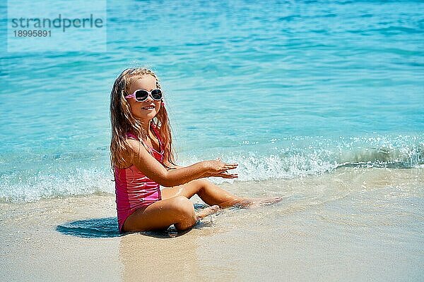 Hübsches kleines Mädchen spielt in türkisfarbenen Meer auf schönen tropischen Strand. Sommer  Strand Spaß und Urlaub Konzept