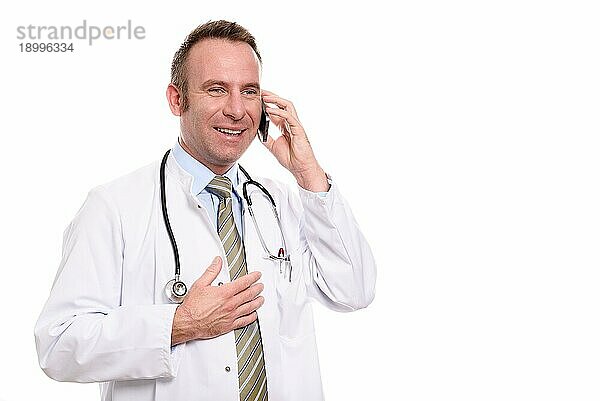 Männlicher Arzt mittleren Alters in Laborkittel und Stethoskop  der mit einem zufriedenen Lächeln einen Anruf auf seinem Mobiltelefon entgegennimmt  während er dem Gespräch zuhört  vor weißem Hintergrund