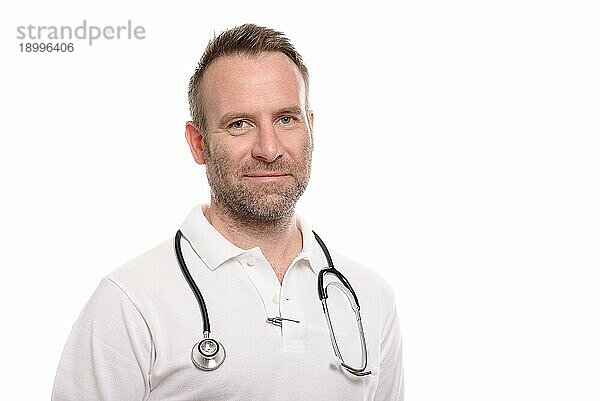 Gutaussehender  selbstbewusster männlicher Arzt oder Krankenpfleger mit verschränkten Armen in einem weißen Hemd und einem Stethoskop um den Hals  vor weißem Hintergrund