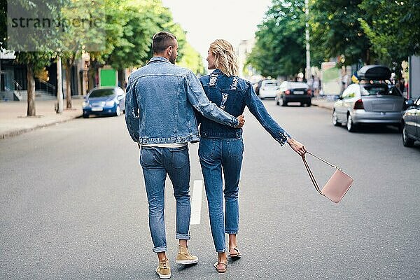 Rückansicht eines sich umarmenden Paares  das auf der Straße weggeht. Liebe  Romantik und Dating Konzept