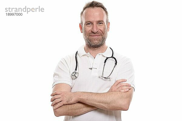 Gutaussehender  selbstbewusster männlicher Arzt oder Krankenpfleger mit verschränkten Armen in einem weißen Hemd und einem Stethoskop um den Hals  vor weißem Hintergrund