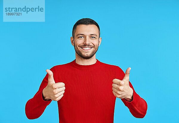 Happy gut aussehend Mann zeigt Daumen hoch Zeichen auf blauem Hintergrund. Gute Idee Konzept