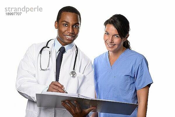Zwei glückliche medizinische Fachkräfte mit Dokument schauen in die Kamera  vor weißem Hintergrund