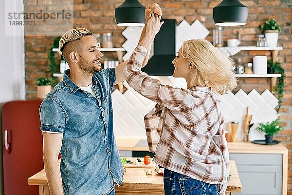 Glückliches junges Paar in der Liebe tanzen in der Küche zu Hause und Spaß haben. Beziehung  Feier  Dating Konzept