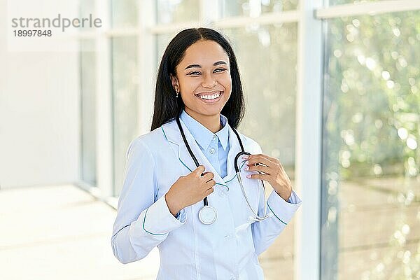 Fröhlich lächelnd afrikanischer amerikanischer Arzt Porträt im Krankenhaus. Medizin  Beruf und Gesundheitswesen Konzept