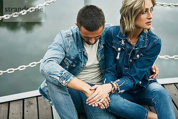 Schöne modische Paar posiert auf Fluss Brücke tragen Denim Jeans. Liebe  Gefühle und Beziehung Probleme Konzept
