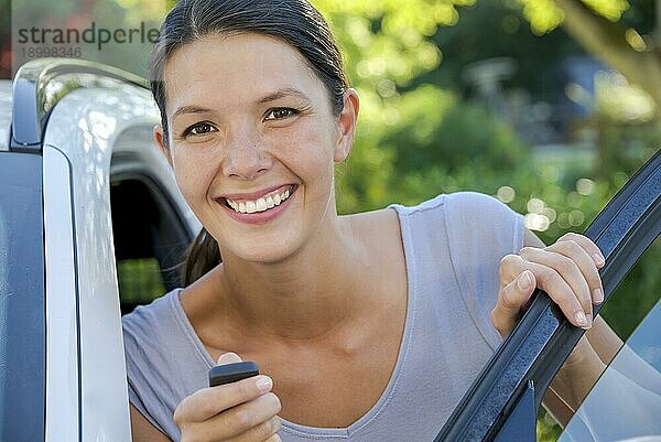 Brünette attraktive Frau zeigt ihre neuen Schlüssel für ihr Auto