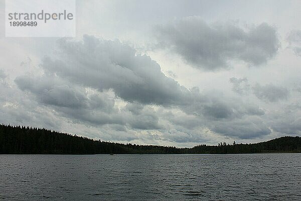 Dramatischer Himmel über einem kleinen See bei Backefors  Schweden  Europa