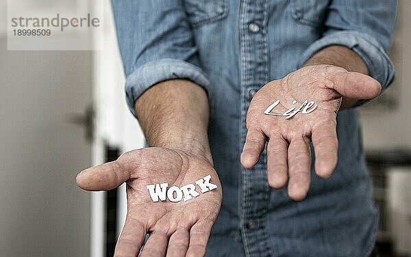 work  life balance  Mann hält ausgeschnittene Schrift