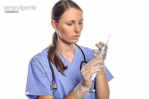 Ernste attraktive Krankenschwester oder Ärztin  die eine große Injektionsspritze hält  während sie überlegt  wie sie eine so große Dosis an Medikamenten am besten verabreichen kann  vor weißem Hintergrund