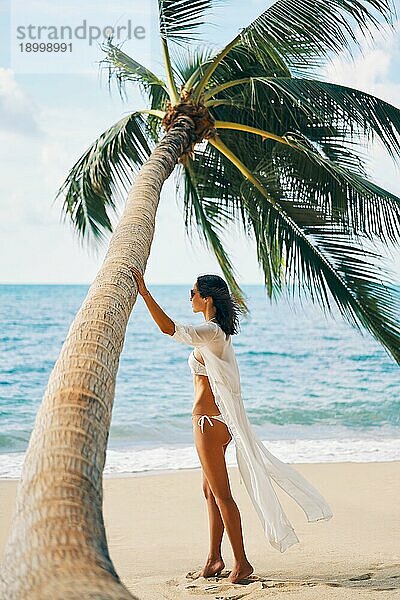 Schöne Frau entspannen auf tropischen Sandstrand auf Palmen Hintergrund. Sommerurlaub  einsam Konzept