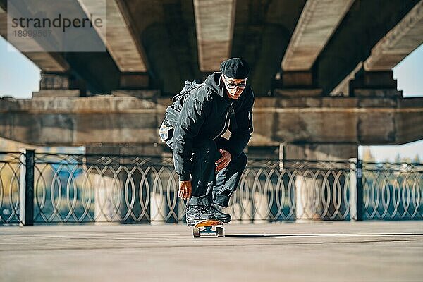 Junger männlicher Skateboarder in Aktion auf der Straße städtischen Hintergrund