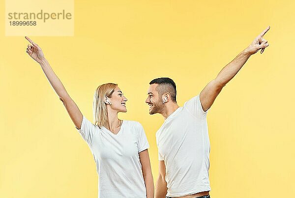 Glückliches Paar tanzen oder feiern Erfolg mit Händen nach oben Geste auf gelbem Hintergrund. Sieg  Triumph und Emotionen Konzept