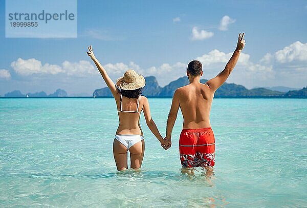 Rückansicht eines glücklichen Paares  das das warme tropische Meerwasser genießt. Sommerurlaub Konzept  Reiseziel