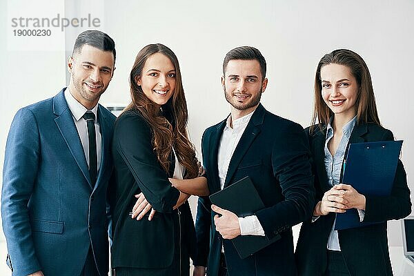 Gruppe von jungen und lächelnden Geschäftsleuten in einem modernen Büro. Erfolg Teamarbeit Konzept