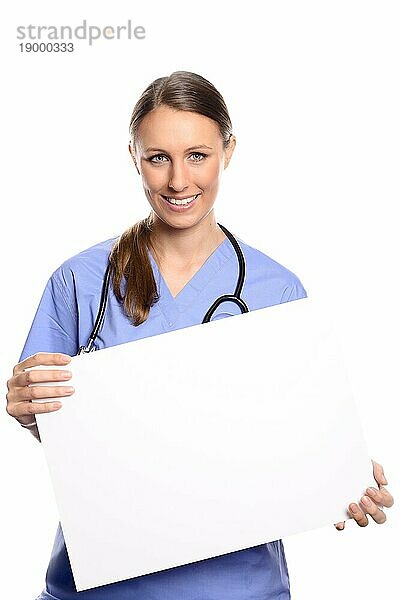 Attraktive junge Ärztin  Tierärztin oder Krankenschwester  die ein leeres weißes Plakat in den Händen hält  mit Platz für Ihren Text oder Ihre Werbung  vor weißem Hintergrund