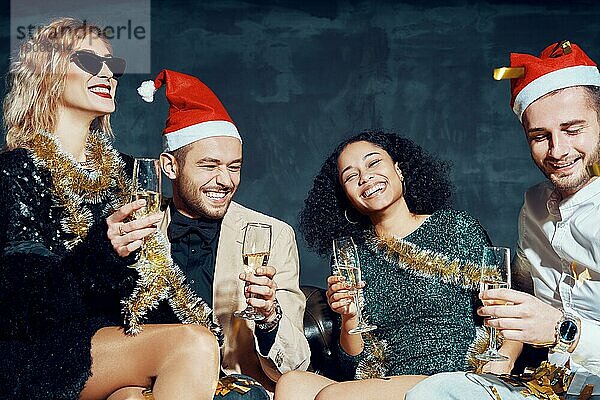 Gruppe von glücklichen lächelnden Freunden feiern Silvester zusammen  Spaß haben und trinken Champagner. Feiertage  Feier  Nachtleben und Konzept