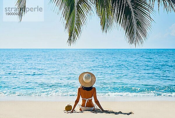 Rückenansicht der jungen Frau entspannen allein auf tropischen Strand. Sommerurlaub Konzept