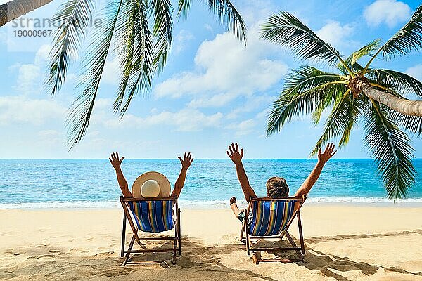Glückliches Paar mit Armen oben entspannen am Strand genießen schönes Meer auf der tropischen Insel. Sommer Strandurlaub Konzept