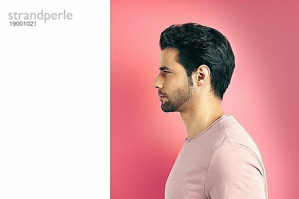 Close up Profil Ansicht Porträt von gut aussehend Mann auf geometrischen rosa weißen Hintergrund