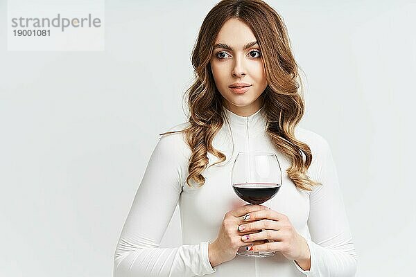 Pretty Mode Frau hält Glas Rotwein auf weißem Hintergrund. Entspannen  Feier Konzept