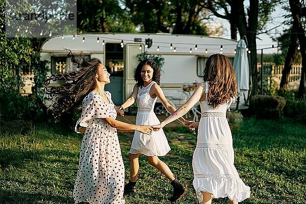 Glückliche schöne Frauen tanzen im Freien auf Picknick. Multi ethnische Mädchen haben Spaß zusammen im Sommer reist genießen Urlaub