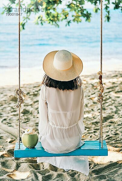 Zurück Blick auf glückliche Frau entspannen auf Schaukel auf schönen Paradiese Strand. Entspannen und Urlaub Konzept