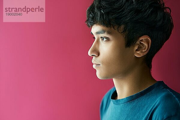 Close up Profil Porträt von gut aussehenden jungen Mann über rosa Hintergrund mit Kopie Raum