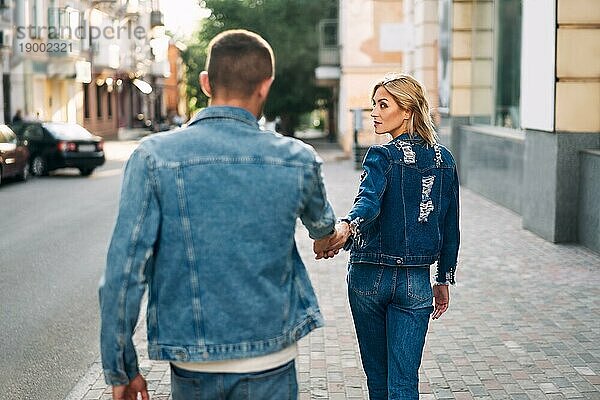 Schöne junge Frau  die auf der Straße geht und einen Mann an der Hand hält. Folgen Sie mir Konzept