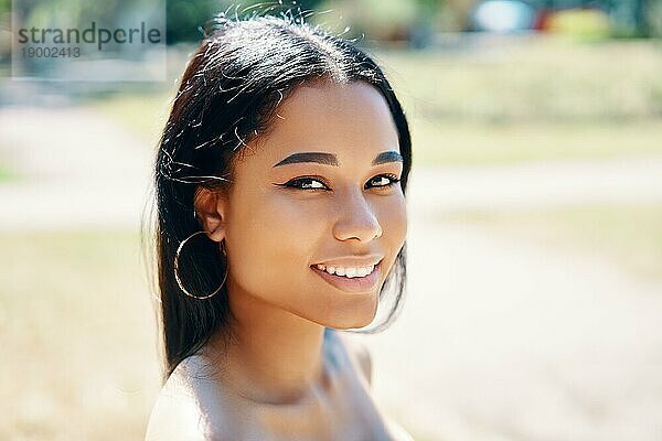Close up Porträt einer schönen jungen afroamerikanischen Frau lächelnd im Freien