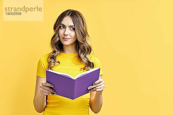 Dreamy positive Mädchen Ruhe mit Buch auf gelbem Hintergrund mit Kopie Raum. Denken  Gedanken  Gefühle Konzept