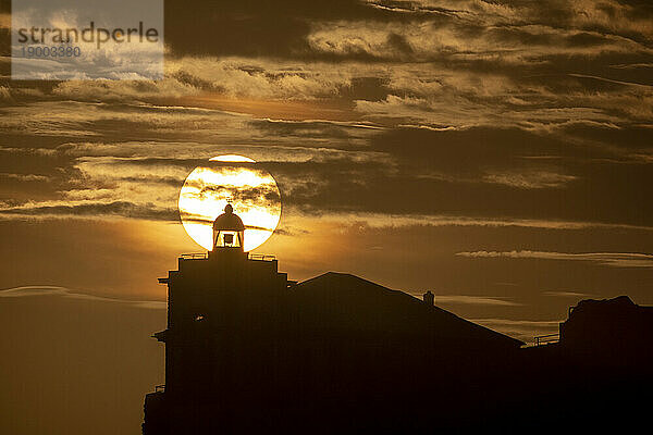 Sonne im Einklang mit der Silhouette des Leuchtturms von Luarca  Asturien  Spanien  Europa