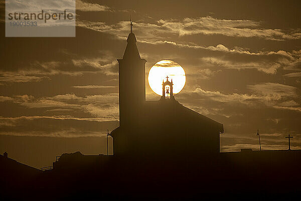 Sonne im Einklang mit der Silhouette der Kirche von Luarca  Asturien  Spanien  Europa