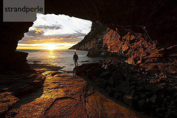 A boy admires a beautiful spring sunset from the Byron cave  Portovenere  La Spezia province  Liguria district  Italy  Europe