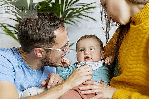 Happy parents playing with baby boy at home