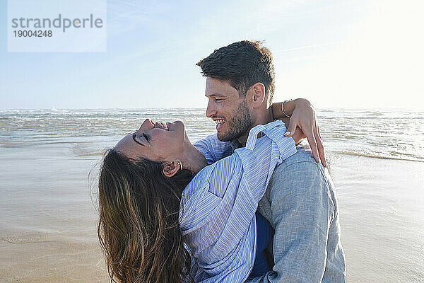 Glückliches Paar  das sich am Strand umarmt