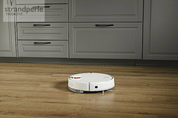 Robot vacuum cleaner near drawers at home