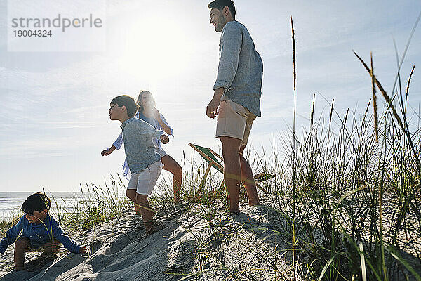 Eltern und Kinder genießen an einem sonnigen Tag den Strand