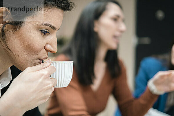 Geschäftsfrau trinkt Kaffee aus einer Tasse im Café