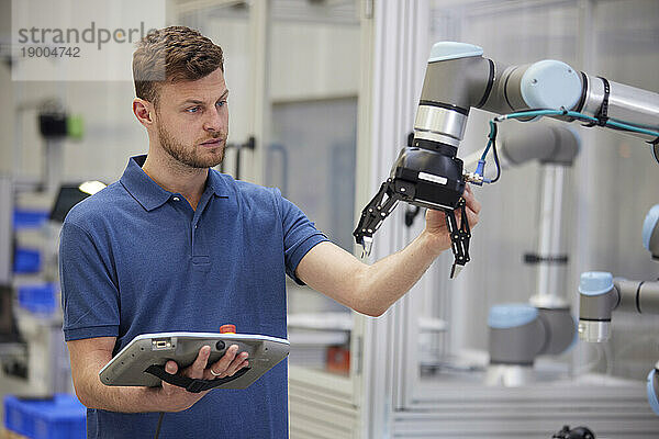 Ingenieur testet modernen Roboterarm in der Fabrik