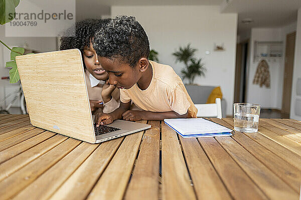 Mutter und Sohn lernen zu Hause am Laptop