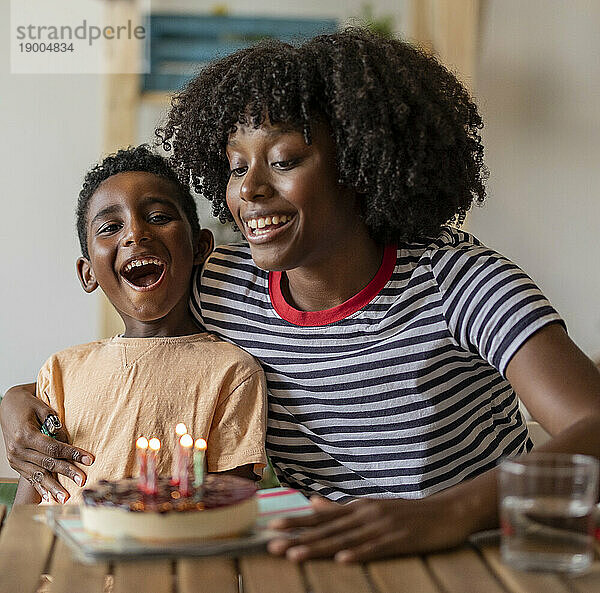 Glückliche Mutter feiert Geburtstag ihres Sohnes mit Kuchen