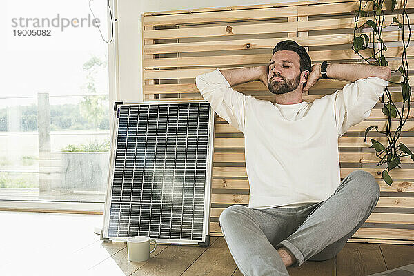 Geschäftsmann entspannt sich zu Hause am Solarpanel
