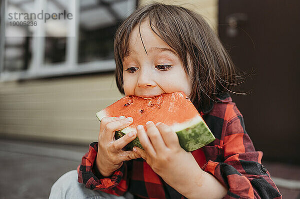 Junge isst Wassermelonenscheibe