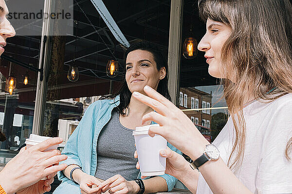 Lächelnde Freunde unterhalten sich im Café